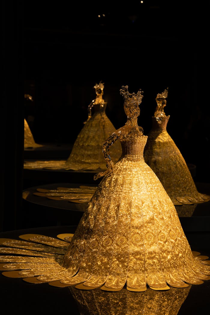 A beautifully lit golden figurine in a dark setting, with multiple reflections enhancing elegance.